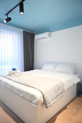 a bedroom with a large white bed with a blue ceiling at Juna's Hotel in Prizren