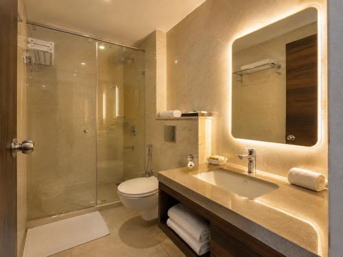 a bathroom with a sink and a toilet and a shower at Hotel Rohit Rohini - New Aesthetic Hotel in Jagannath Puri with Restaurant, Parking, Free Wi-fi, Prime Location in Puri