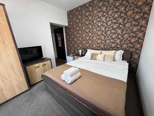 a bedroom with a large bed and a television at Harmonie Radauti in Rădăuţi