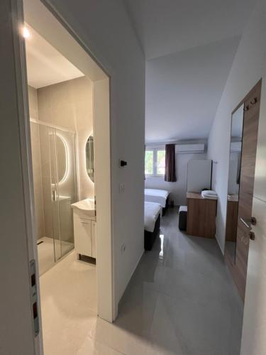 a bedroom with a bed and a bathroom with a mirror at ROOMS Međugorje in Međugorje