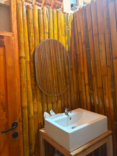 a bathroom with a sink and a wooden wall at Queen house in Waikabubak