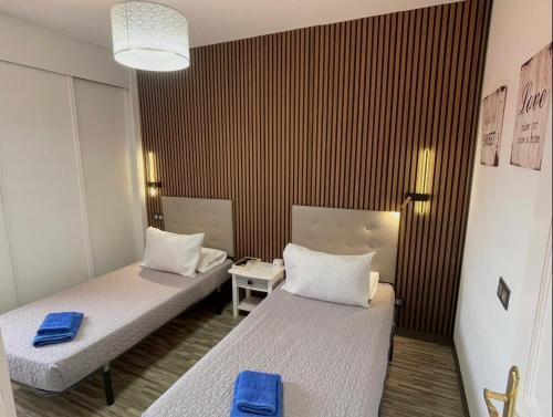 a room with two beds with blue towels at Villa Hyc Playa de las burras in Maspalomas