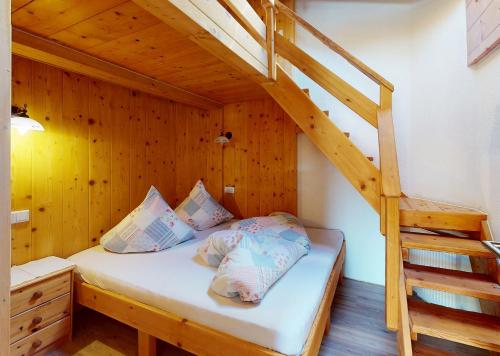 a bedroom with a bunk bed with a ladder at Gipfelblick Appartements in Umhausen