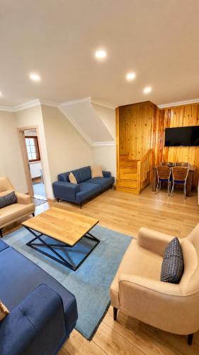 a living room with blue couches and a table at Raha Villa Bungalow in Uzungöl