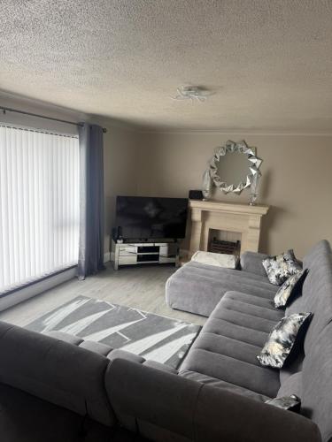 a living room with a couch and a fireplace at Suzies Escape in Bovevagh