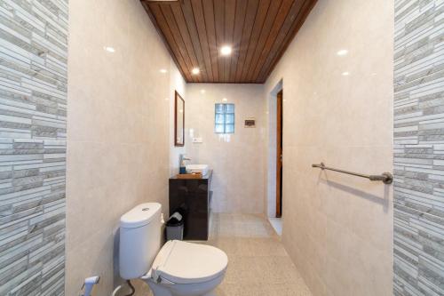 a bathroom with a toilet and a sink at Uma Jineng Villa in Munggu