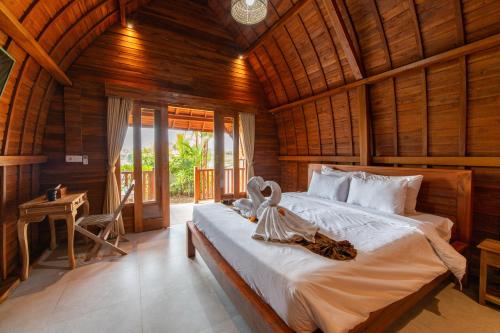 a bedroom with a bed in a wooden room at Uma Jineng Villa in Munggu