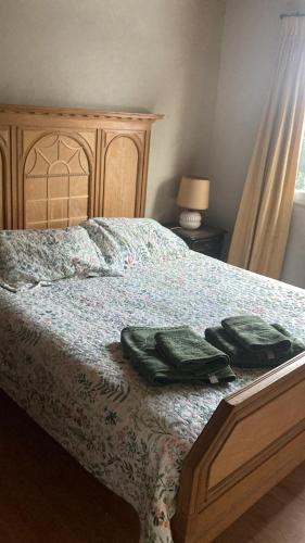 a bedroom with a bed with two green towels on it at Casiopea bungalo in San Carlos de Bariloche