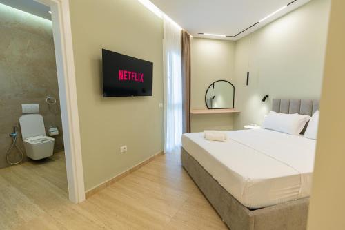 a bedroom with a bed and a tv on the wall at Sirena Garden Resort in Tale