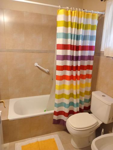 a bathroom with a colorful shower curtain and a toilet at Casiopea bungalo in San Carlos de Bariloche