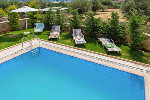 an overhead view of a swimming pool with chairs and tables at Cottage in Adele in Ádhele