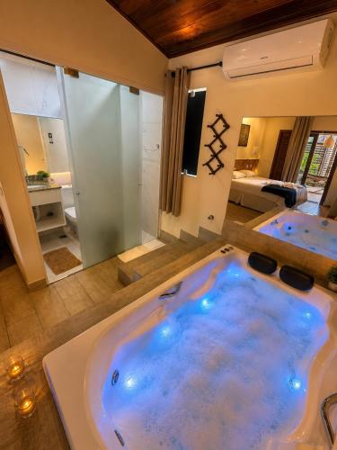 a large jacuzzi tub in the middle of a bathroom at Pousada Charmosa Lua Nova Pipa - Chales com Jacuzzi e Hidro in Pipa