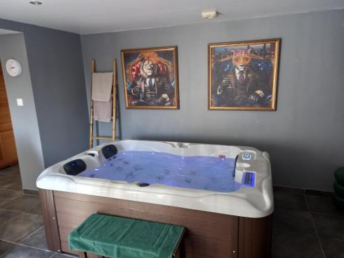 a bath tub with blue water in a room at Un moment zen à Warhem in Warhem