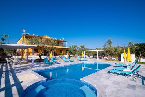 una piscina con sillas azules y un edificio en Studios Gagos, en Astris