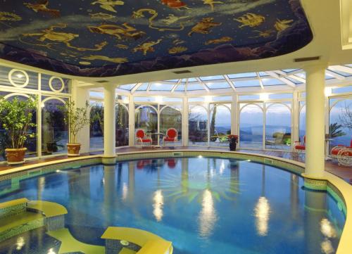 a swimming pool in a hotel with a ceiling at Villa Althea in Mango