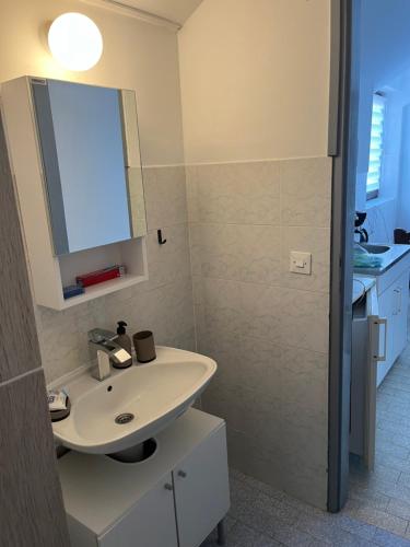 a bathroom with a sink and a mirror at Apartman Jovana in Bečej