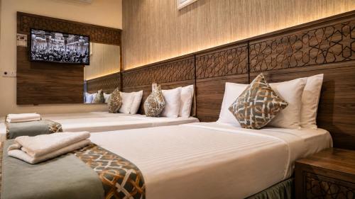 a hotel room with two beds and a television at فندق زهرة الفرسان in Mecca