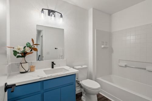 a bathroom with a sink and a toilet and a mirror at Permana Apartment in Manila