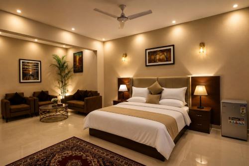 a bedroom with a large bed and a living room at Elite Creek Clifton in Karachi