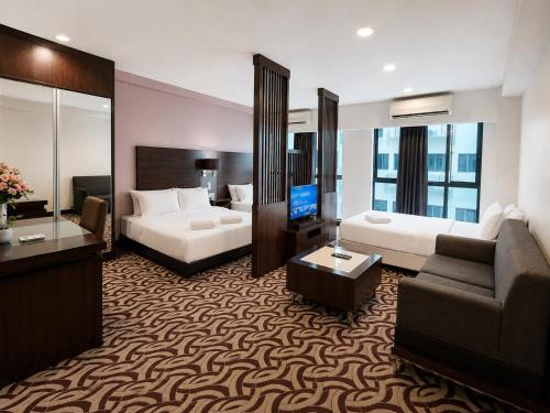 a hotel room with a bed and a couch at Cozy Studio at SCSP Suites in Kota Kinabalu