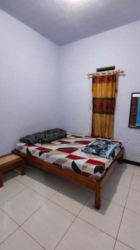 a bed in a room with a checkered bed sidx sidx sidx at Bromo Jay House Homestay I in Sukapura