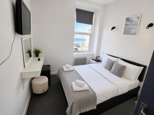 a bedroom with a white bed and a window at Alexandra Hotel Blackpool in Blackpool