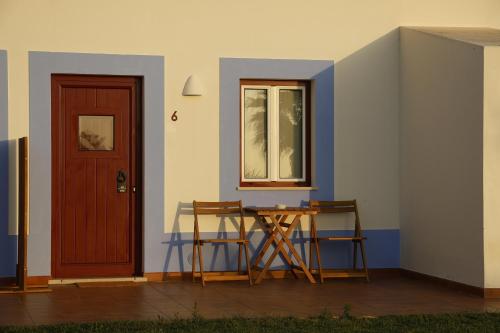 a room with a table and two chairs and a door at O Monte da Estrada in Zambujeira do Mar