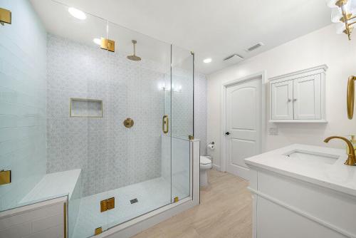 a bathroom with a shower with a sink and a toilet at Backyard Oasis with Pool & Games in West Palm Beach