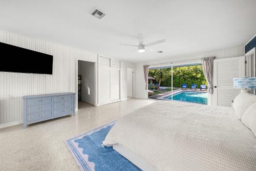 a bedroom with a bed and a tv and a pool at Backyard Oasis with Pool & Games in West Palm Beach