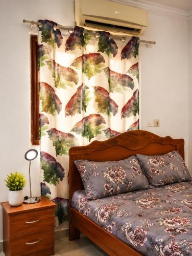 a bedroom with a bed and a floral wall at Ouedraogo Property Management in Ouagadougou
