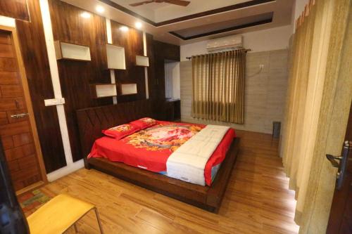 ein Schlafzimmer mit einem Bett mit roter Bettdecke in der Unterkunft Krishibid Resort 