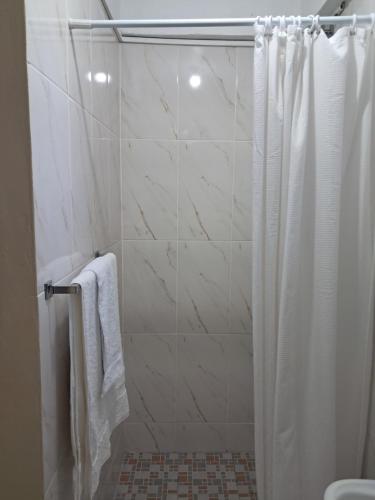 a bathroom with a shower with a white shower curtain at Ebenezer Comfort in Bellevue Chopin
