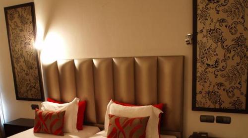 a hotel room with a bed with red and white pillows at Hotel Dighton in Oliveira de Azemeis