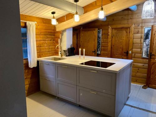 a kitchen with a sink and a counter with candles at Cozy and authentic log house in Dronningmølle