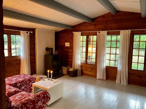 a living room with a couch and a table at Cozy and authentic log house in Dronningmølle