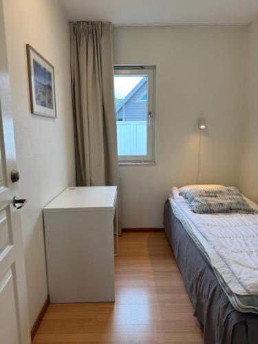 a bedroom with a bed and a desk and a window at Åhus Havsvillor in Åhus