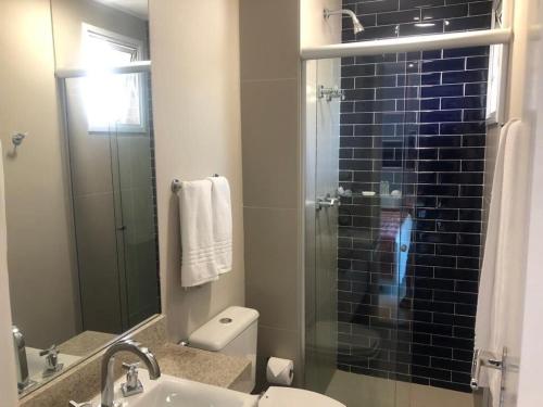 a bathroom with a toilet and a glass shower at 2 quartos- Unique Ex-Estanconfor veja o mar do ap 1408 in Santos