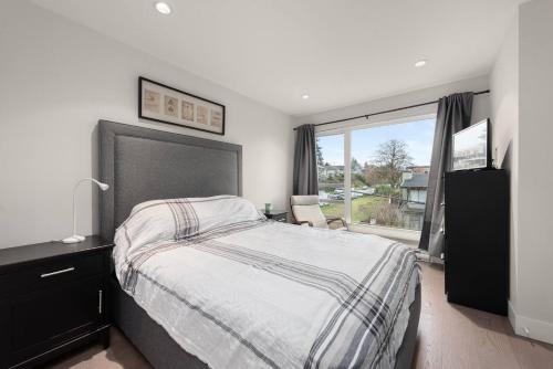 a bedroom with a large bed and a window at Elite Townhouse @ the Shipyards in North Vancouver