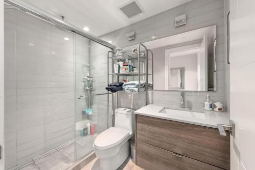 a bathroom with a toilet and a sink and a shower at Elite Townhouse @ the Shipyards in North Vancouver