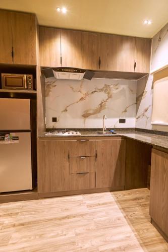 a kitchen with wooden cabinets and a sink and a refrigerator at The Chevron House in Ikuata