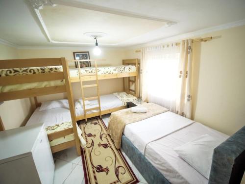 a bedroom with two bunk beds and a window at Vila Muca in Peshkopi