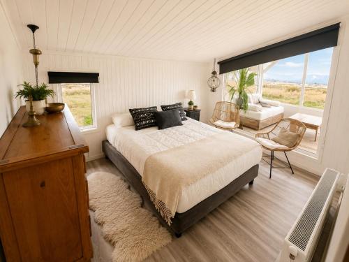a bedroom with a bed and a desk and a window at Domos by Toore Patagonia in Puerto Natales