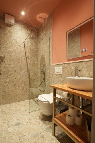 a bathroom with a sink and a toilet and a shower at Eden Center Rooms in Durrës