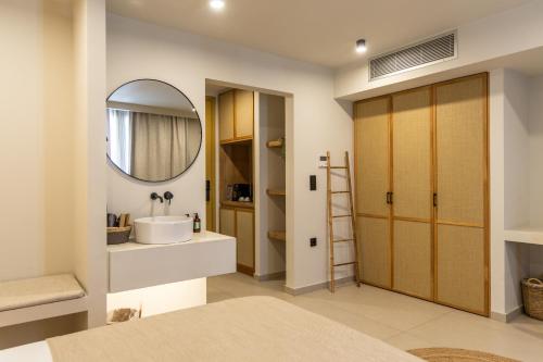 a bathroom with a sink and a mirror at Portiani Suites in Adamantas