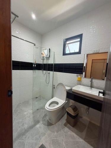 a bathroom with a toilet and a sink and a shower at ซันไบร์ท พลูวิลล่า 2 in Ban Huai Yai