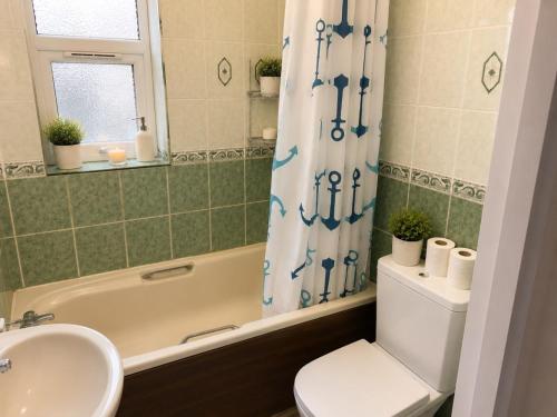 a bathroom with a tub and a toilet and a sink at Harman Suites 1 & 2 in Leeds