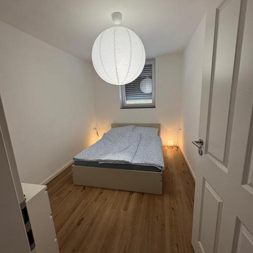 a small bedroom with a bed and a chandelier at TourBase Dahlem in Dahlem