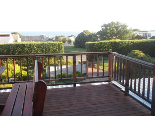a wooden deck with a bench and bushes at Casa Del Mar in Hermanus