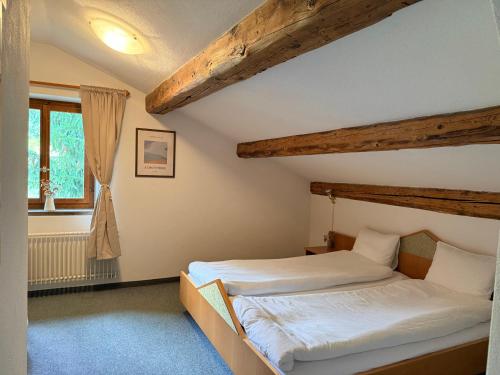 a bedroom with two beds and a window at Hotel Alp Sur in Mühlen