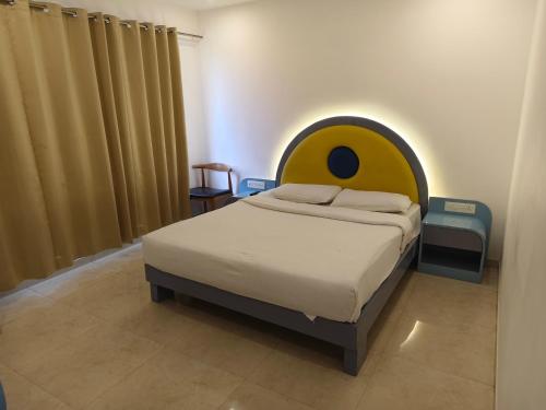 a bedroom with a bed with a smiley face head at The Moon Hotel Panvel in Āpta
